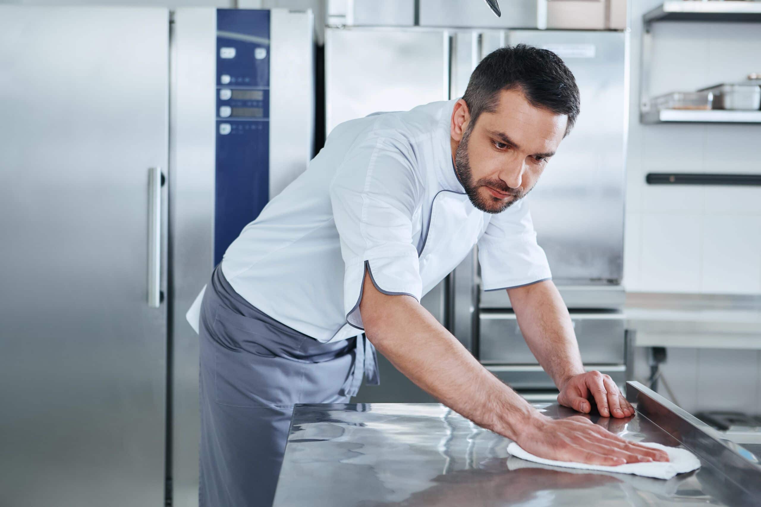 Koch reinigt Edelstahl Oberflächen in Küche