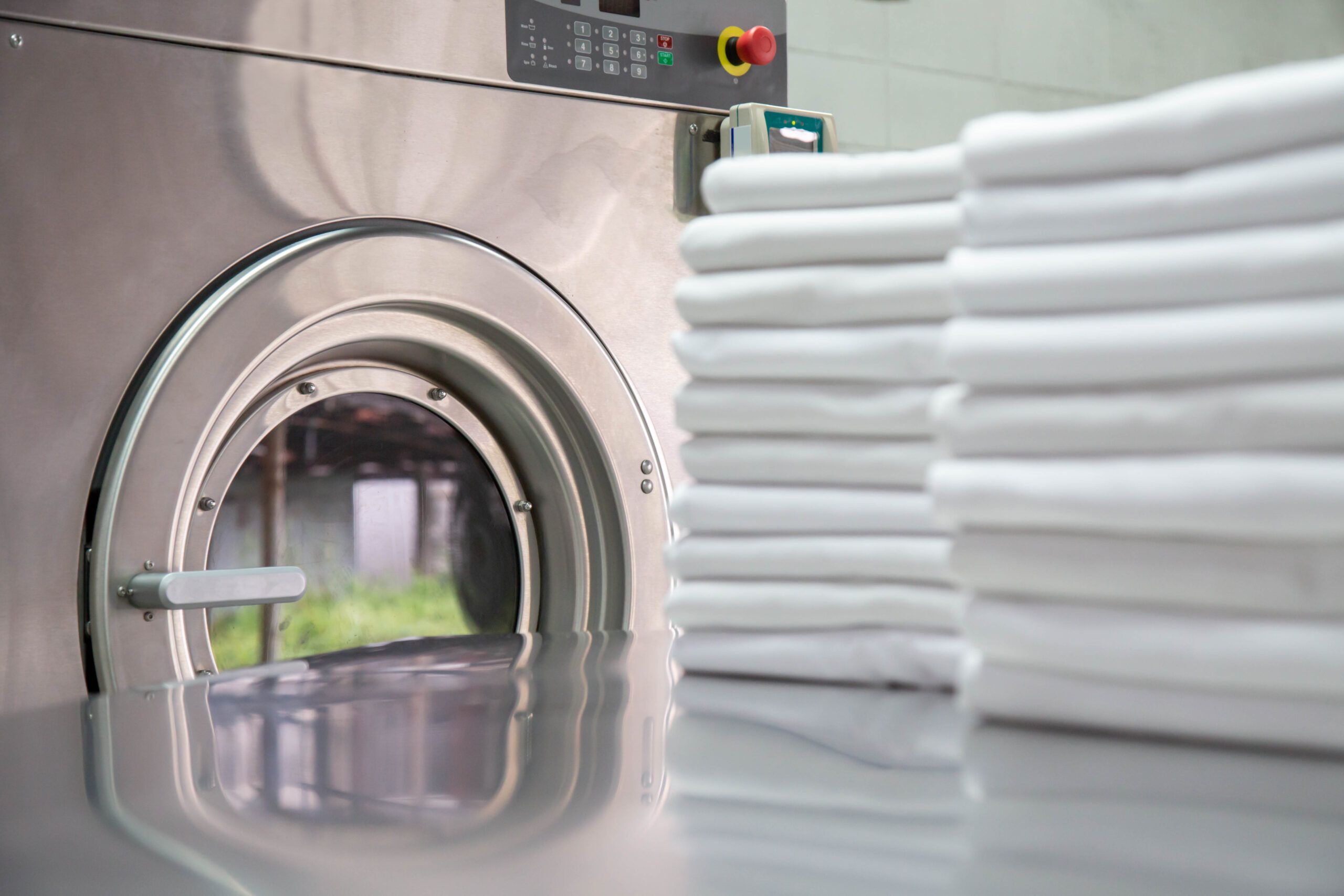 Sauber gefaltete weiße Tücher liegen vor Industrie Waschmaschine